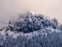 Wolken hüllen die verschneite Scheibenwand im Abendlicht ein